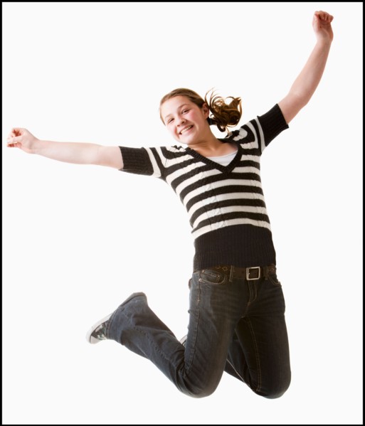 Studio shot of girl (12-13) jumping with arms raised. Photo : Mike Kemp