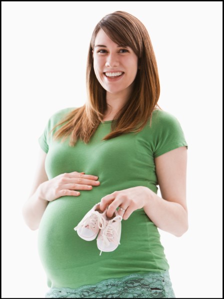 Studio Shot of woman holing baby booties. Photo : Mike Kemp