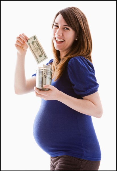 Studio Shot of woman holing baby jar with money. Photo : Mike Kemp