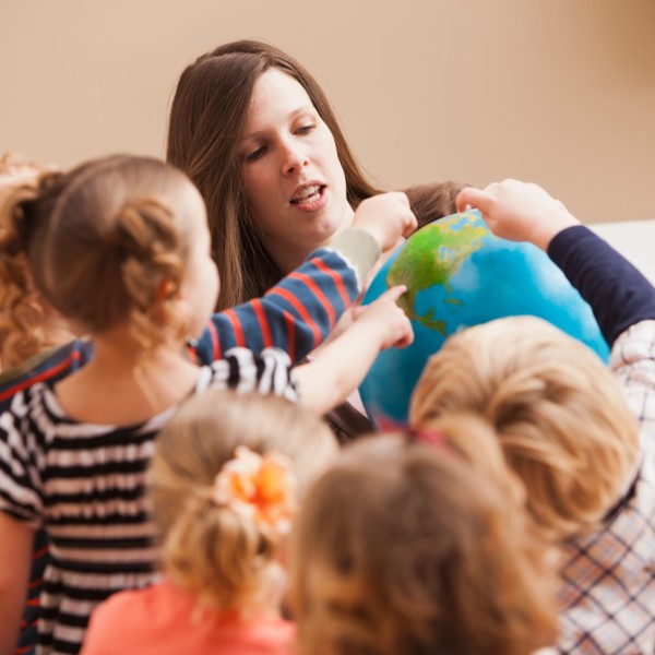 Teacher with children (2-3, 4-5) learning geography. Photo : Mike Kemp