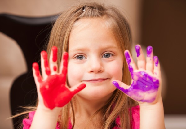 Girl (4-5) with paint covered hands. Photo : Mike Kemp
