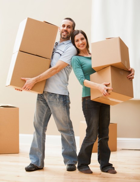 Mid adult couple carrying cardboard boxes. Photo : Mike Kemp