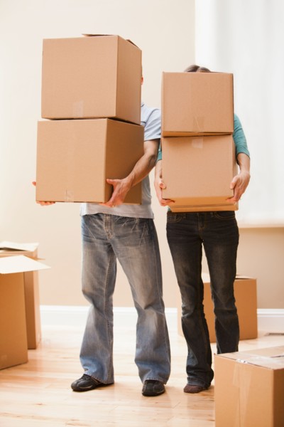Mid adult couple carrying cardboard boxes. Photo : Mike Kemp