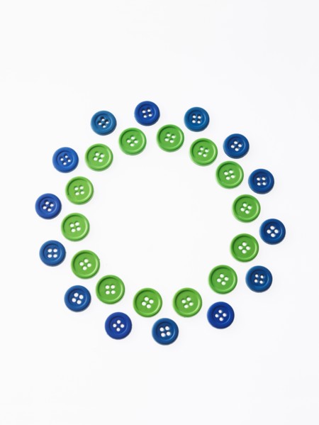 Studio shot of green and blue buttons arranged in circle. Photo : David Arky
