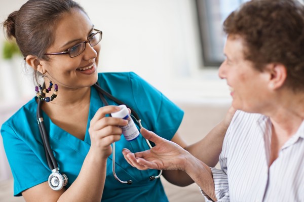 Young female nurse attending patient. Photo : Tim Pannell