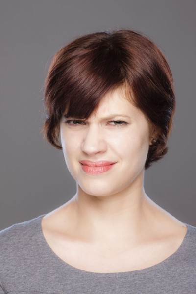 Studio shot of confused young woman. Photo : Rob Lewine