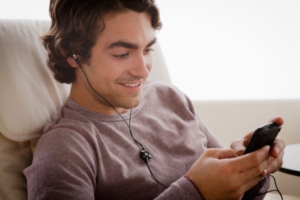 Young man listening music on armchair. Photo : Rob Lewine