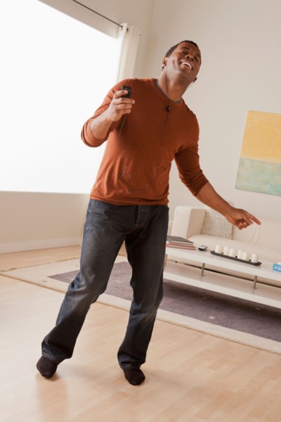 Mid adult man dancing at home. Photo : Rob Lewine