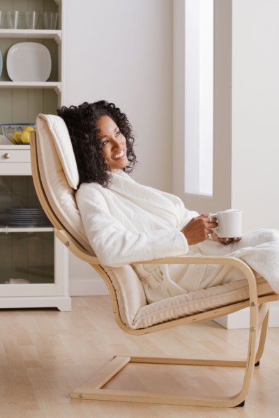 Woman drinking coffee in armchair in morning. Photo : Rob Lewine