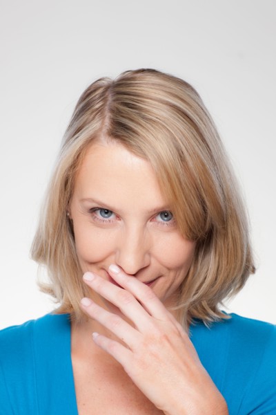 Studio shot of mid adult woman covering lips. Photo : Rob Lewine