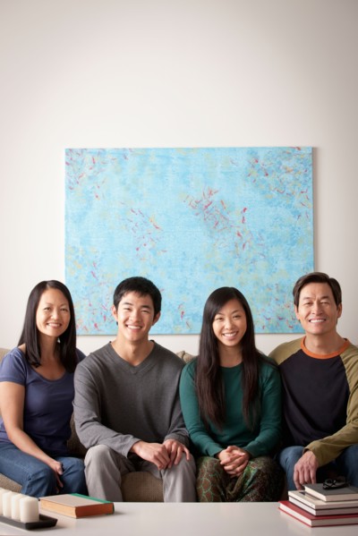 Portrait of family sitting on couch. Photo : Rob Lewine