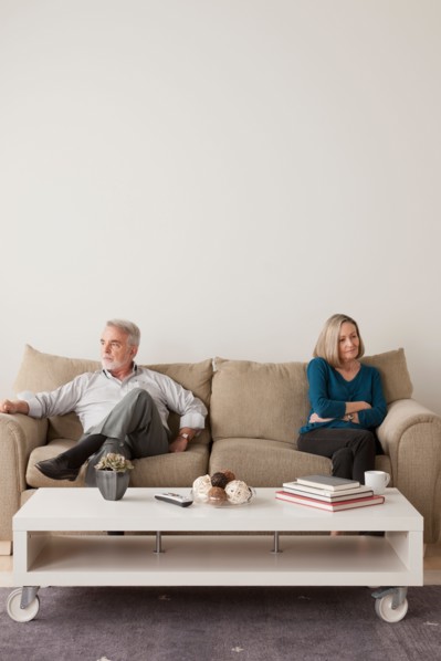 Angry senior couple sitting on sofa. Photo : Rob Lewine