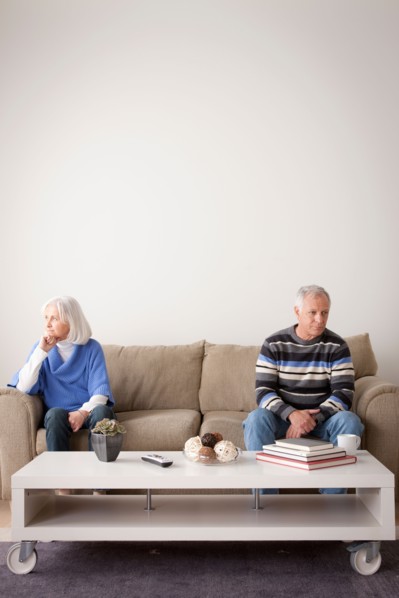 Angry senior couple sitting on sofa. Photo : Rob Lewine