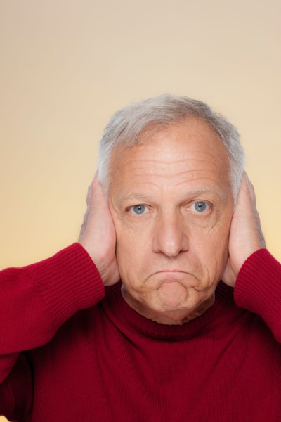 Studio shot of senior man covering ears. Photo : Rob Lewine