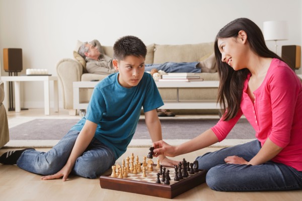 Siblings playing chess game. Photo : Rob Lewine
