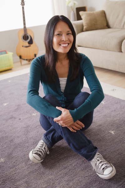 Smiling woman sitting on floor. Photo : Rob Lewine