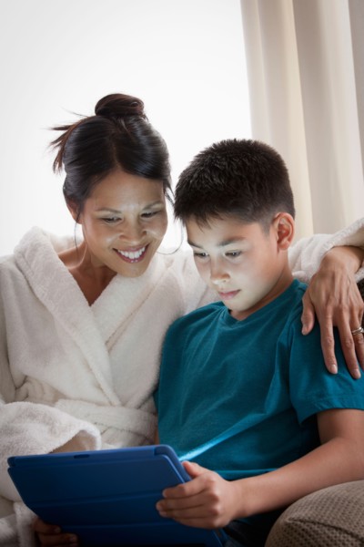 Mother embracing son using laptop. Photo : Rob Lewine
