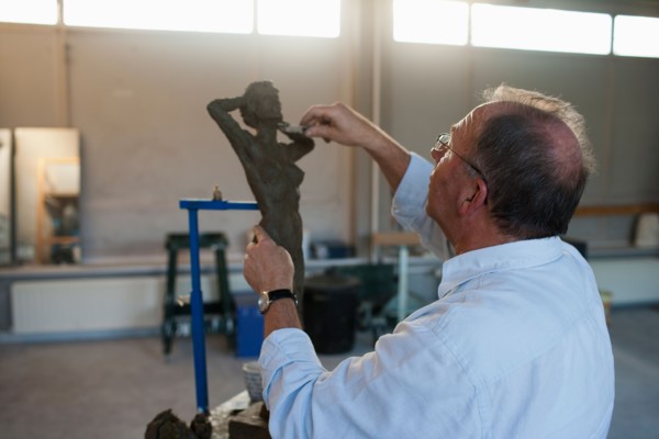 Retired man working on sculpture. Photo : Mark de Leeuw