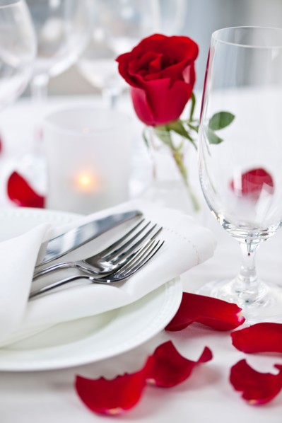 Dishes and cutlery prepared for meal decorated with red roses. Photo : Elena Elisseeva