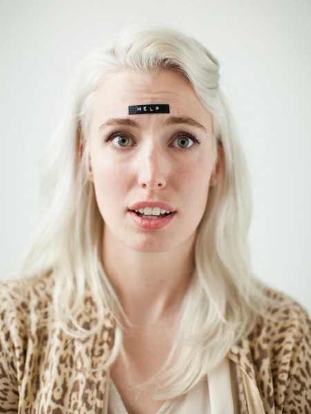 Portrait of young woman with word help on forehead. Photo : Jessica Peterson