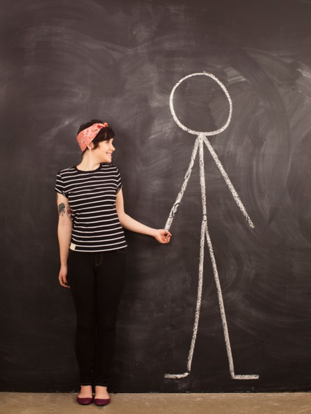 Portrait of young woman in front of blackboard. Photo : Jessica Peterson