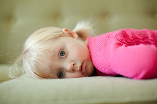 Portrait of baby girl (18-23 months) resting on sofa. Photo : Jessica Peterson