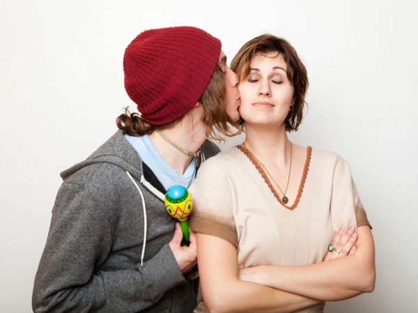 Studio Shot of young man kissing young woman. Photo : Jessica Peterson