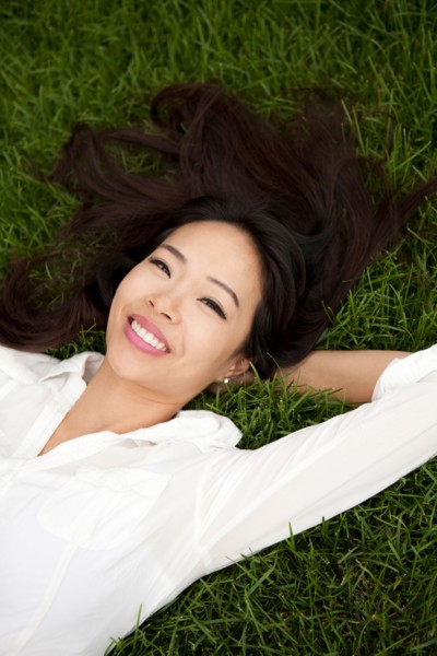 High angle view of smiling woman lying on lawn. Photo : Jessica Peterson
