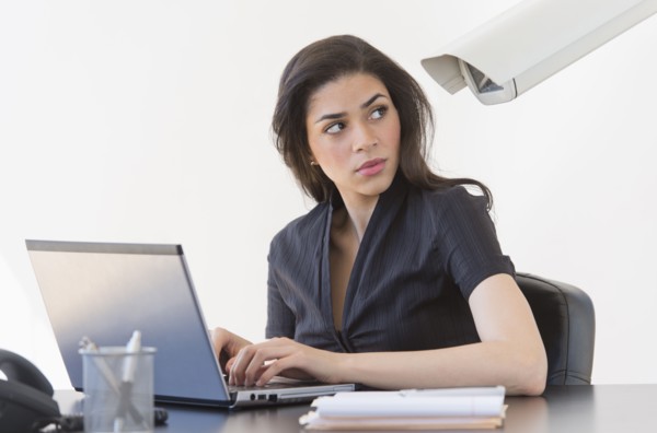 Businesswoman spied on by cctv camera.