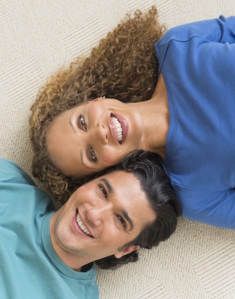 Portrait of couple lying on floor.