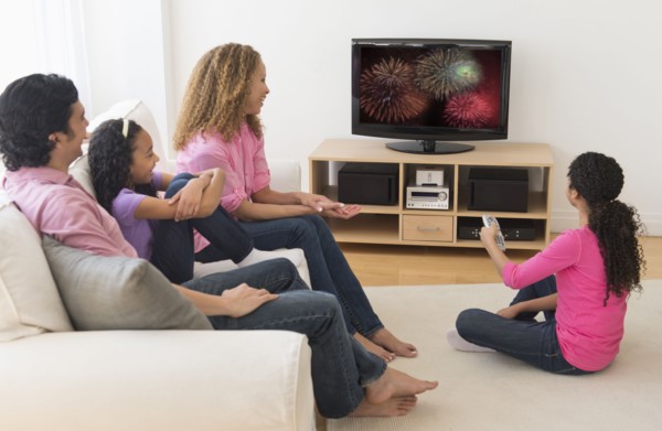 Parents with daughters (10-13) watching tv.