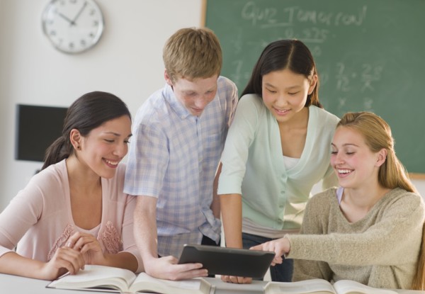 Students (14-19) using tablet pc in classroom.