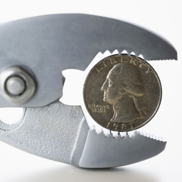 Wrench squeezing coin. 
Photo: Jamie Grill