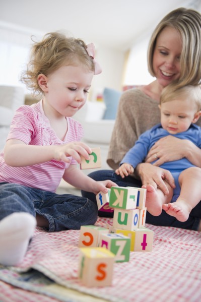 Mother playing with children (2-3, 6-11 months) at home. 
Photo: Jamie Grill