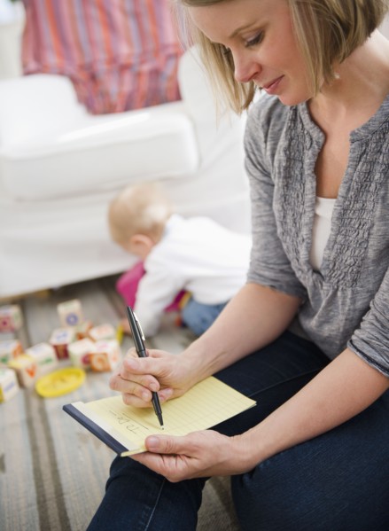 Mother doing notes, son (6-11 months) playing in background. 
Photo : Jamie Grill