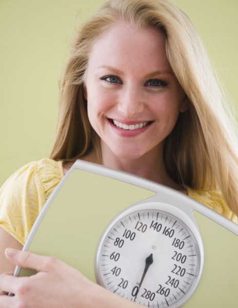 Woman holding bathroom scale. 
Photo: Jamie Grill