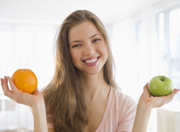 Woman holding orange and apple. 
Photo: Jamie Grill