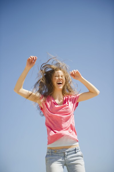 Happy woman jumping outdoors. 
Photo : Jamie Grill