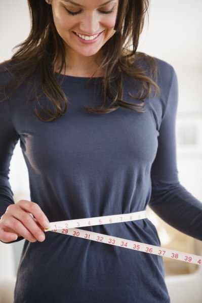 Woman measuring herself with measuring tape. 
Photo: Jamie Grill