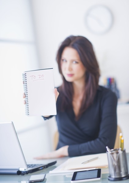 Businesswoman at desk showing to do list. 
Photo : Daniel Grill