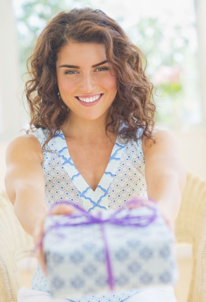 Smiling woman giving present. 
Photo: Daniel Grill