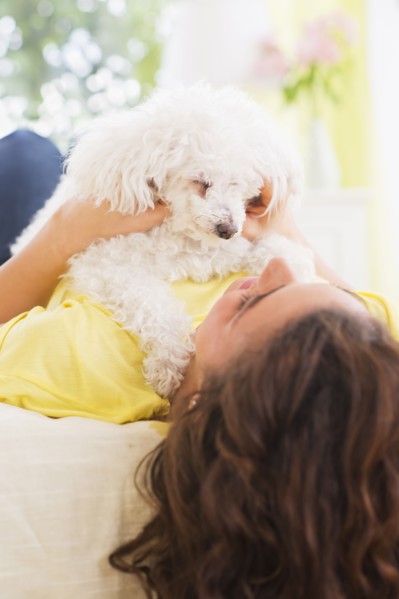 Woman lying on bed with her dog. 
Photo : Daniel Grill