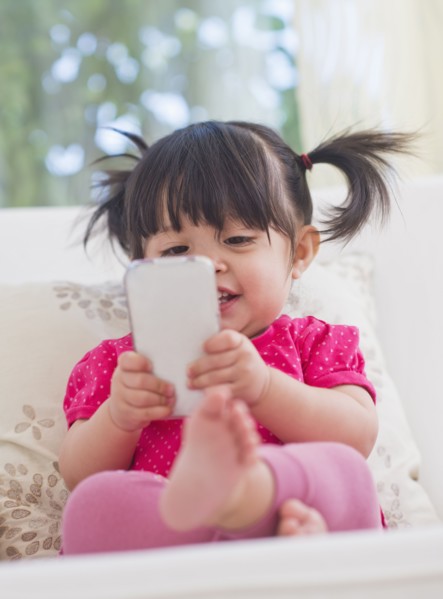 Baby girl (12-17 months) playing with mobile phone. 
Photo : Daniel Grill