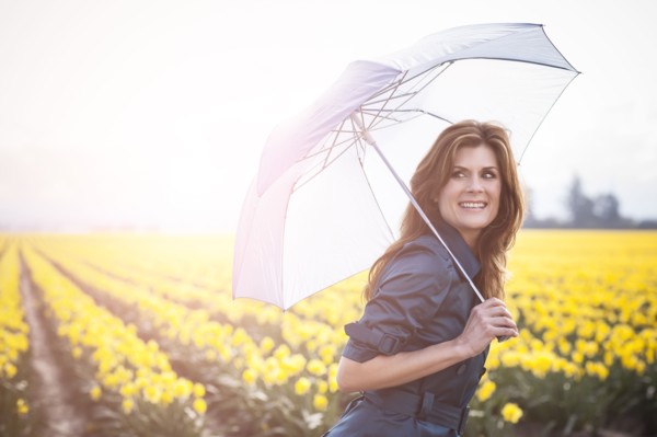 USA, Washington, Skagit Valley, Woman with umbrella against daffodil field. 
Photo : Take A Pix