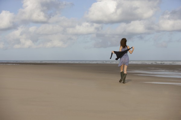 France, Pas-de-Calais, Escalles, Young woman strolling on empty beach. 
Photo : Jan Scherders