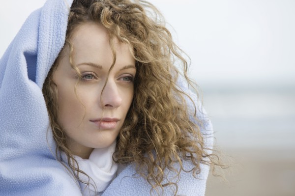 Portrait of young woman wrapped in blanket. 
Photo: Jan Scherders