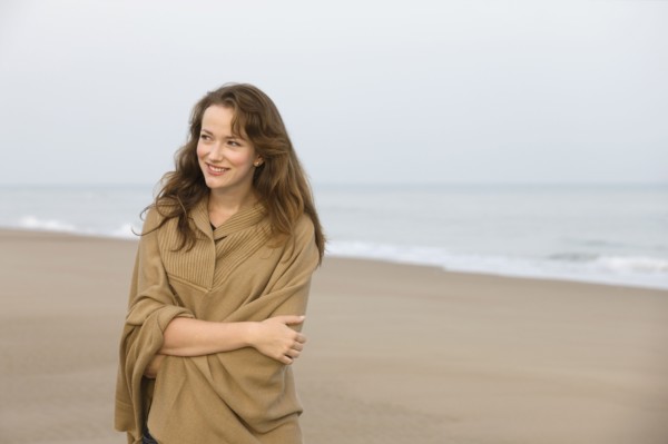 Young woman strolling on empty beach. 
Photo : Jan Scherders