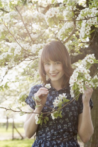 Portrait of young woman in blooming orchard. 
Photo: Jan Scherders