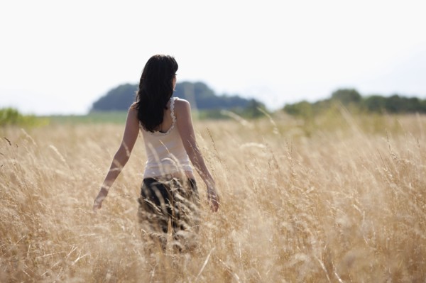 France, Picardie, Albert, Young woman strolling in cornfield. 
Photo: Jan Scherders