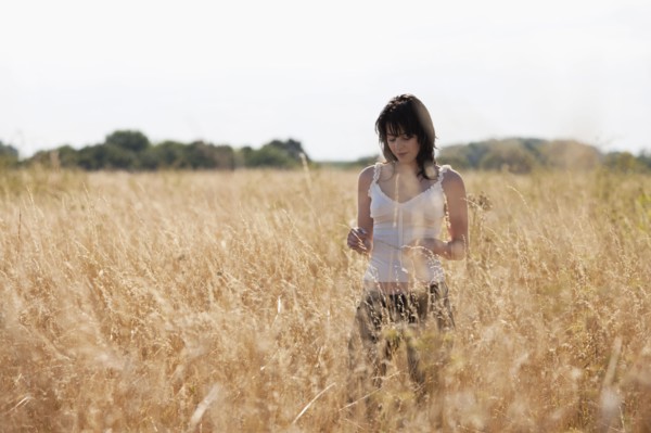 France, Picardie, Albert, Young woman strolling in cornfield. 
Photo: Jan Scherders